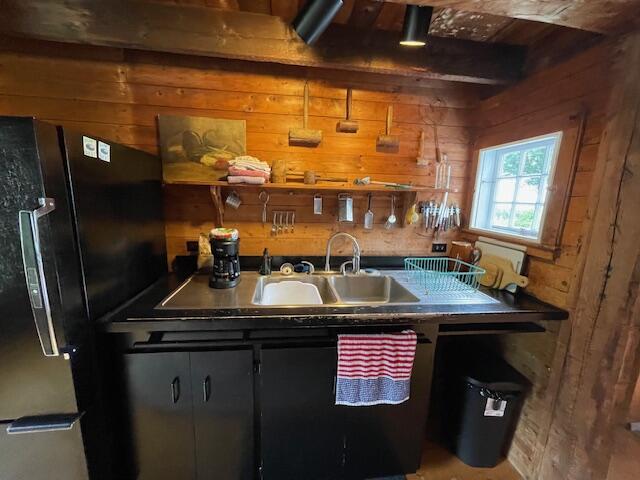 38 Kingsbury Ln, Perry, ME 04667 - kitchen with wooden walls and freestanding refrigerator