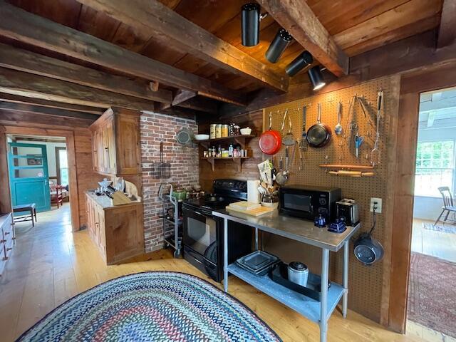 38 Kingsbury Ln, Perry, ME 04667 - bar area with black appliances, a wood ceiling with exposed beams, light wood-type flooring, and wooden walls