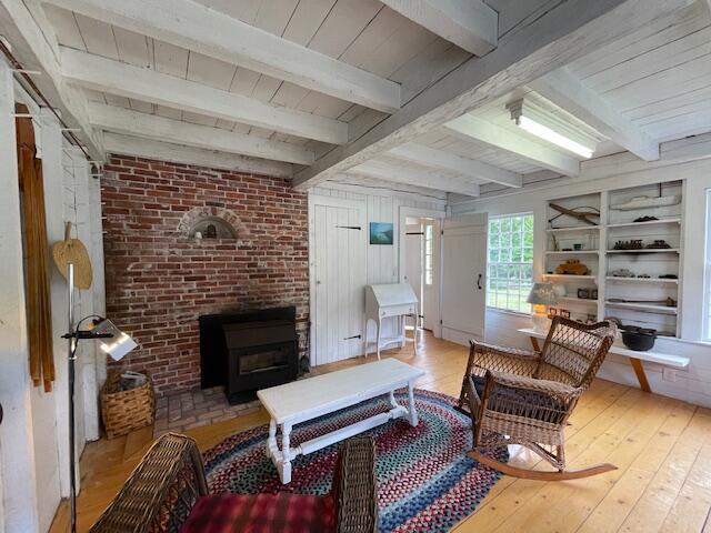 38 Kingsbury Ln, Perry, ME 04667 - living area with hardwood / wood-style flooring, a wood stove, and a wooden ceiling with exposed beams