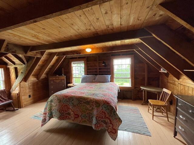 38 Kingsbury Ln, Perry, ME 04667 - bedroom with wooden walls, wooden ceiling, and light wood-style floors