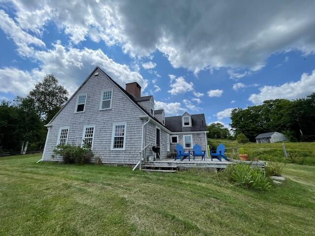 38 Kingsbury Ln, Perry, ME 04667 - back of property with a deck, a yard, and a chimney
