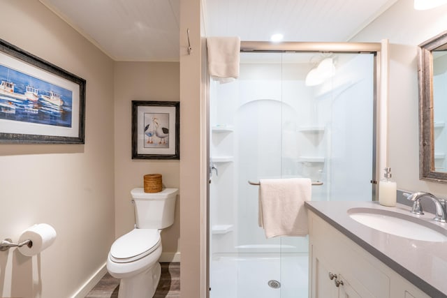 bathroom with vanity, toilet, a shower with door, and ornamental molding