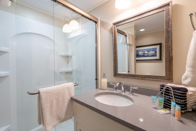 bathroom with ornamental molding, vanity, and walk in shower