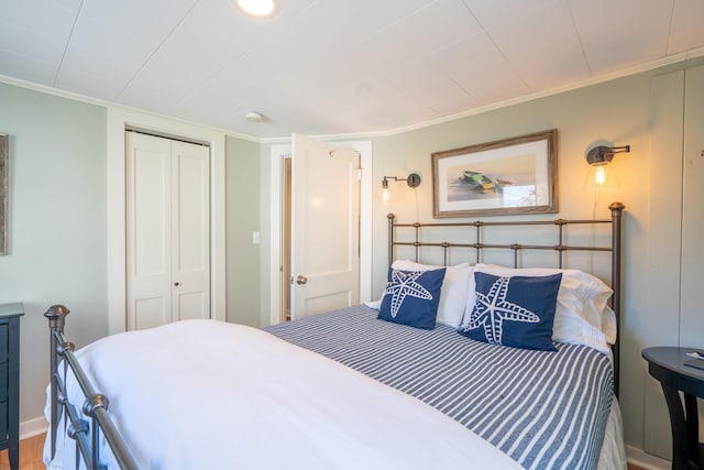 bedroom featuring a closet, crown molding, and hardwood / wood-style floors