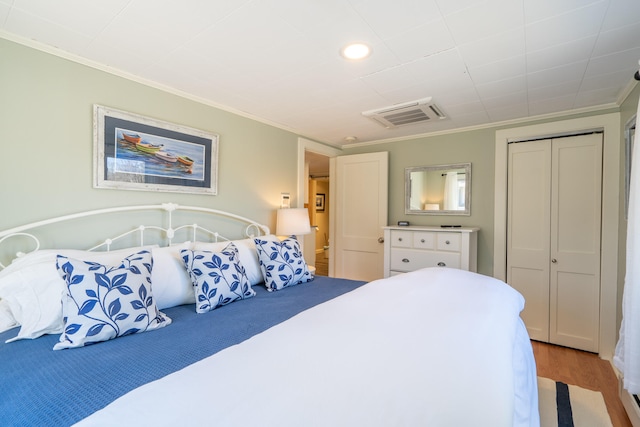 bedroom with a closet, light wood-type flooring, and ornamental molding