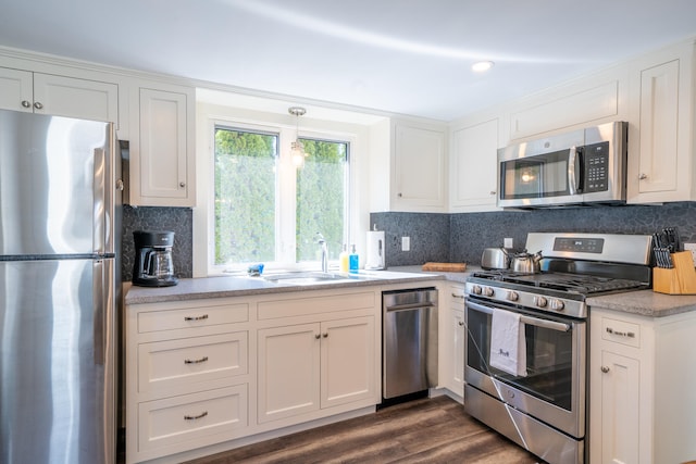 kitchen with sink, appliances with stainless steel finishes, dark hardwood / wood-style flooring, and decorative backsplash