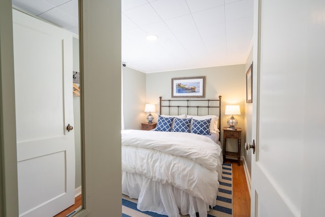 bedroom with light wood-type flooring and ornamental molding