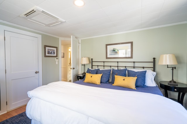 bedroom featuring crown molding and wood-type flooring