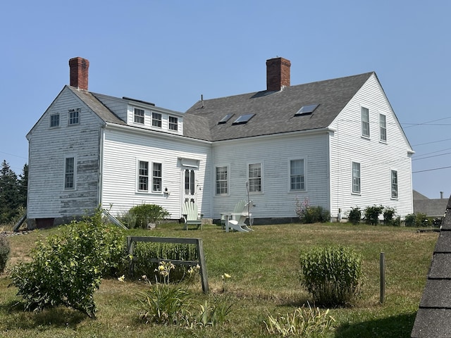 rear view of house featuring a lawn