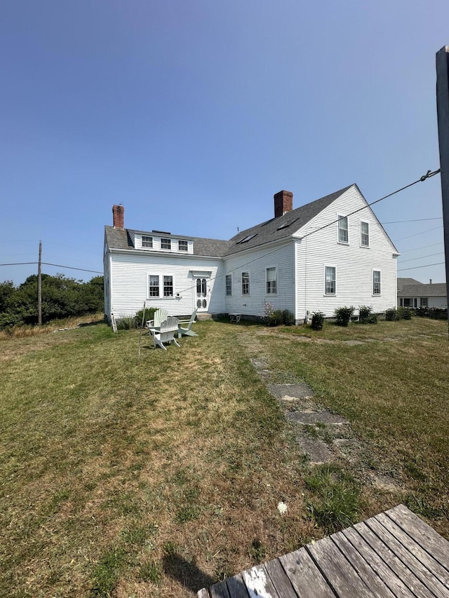 back of house with a lawn