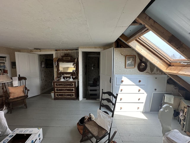 additional living space with vaulted ceiling with skylight and light wood-type flooring