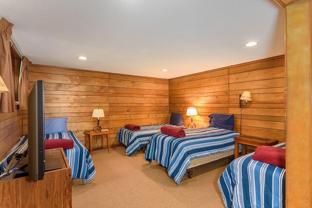 carpeted bedroom featuring wooden walls