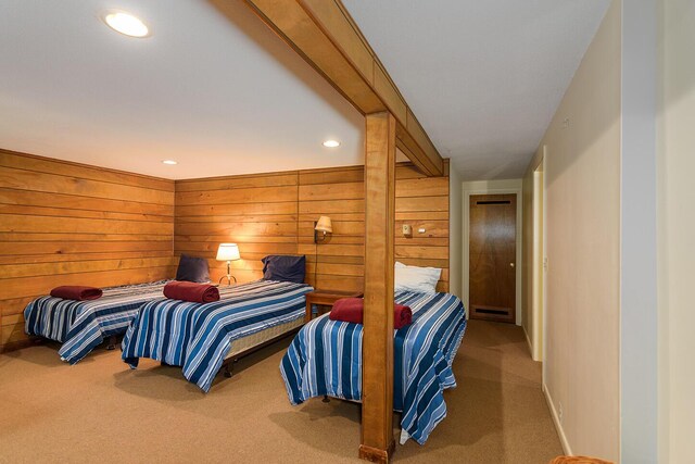 carpeted bedroom featuring wooden walls