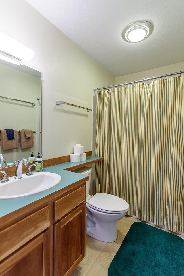 bathroom with tile patterned floors, toilet, and vanity