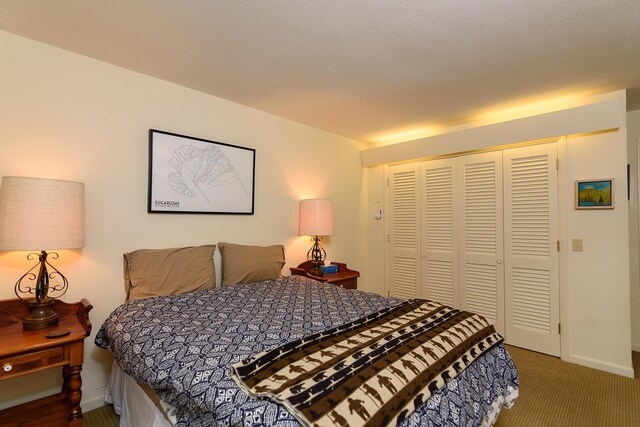 carpeted bedroom with a textured ceiling and a closet