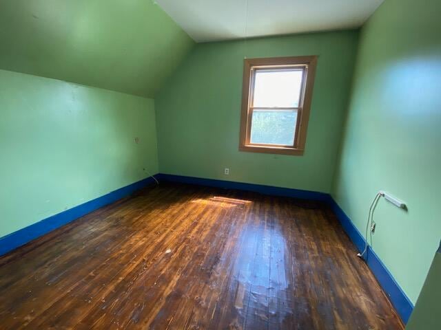 additional living space with vaulted ceiling and hardwood / wood-style floors