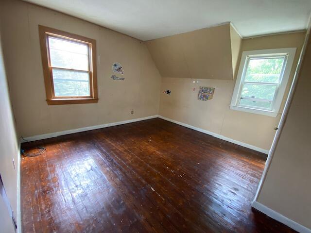 additional living space featuring dark hardwood / wood-style floors and vaulted ceiling