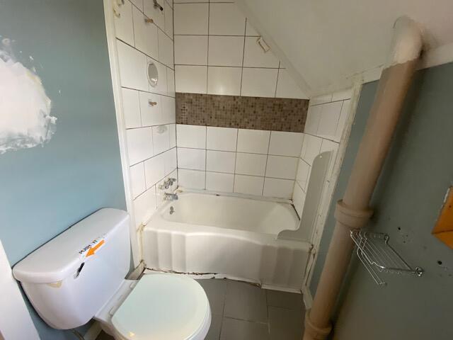 bathroom with tile patterned floors, toilet, and vaulted ceiling