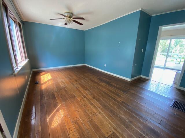 empty room with hardwood / wood-style flooring, crown molding, and ceiling fan