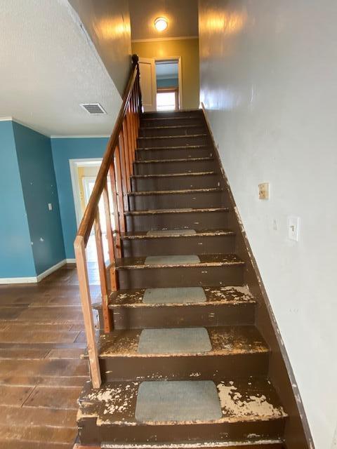 stairway with plenty of natural light and dark hardwood / wood-style floors