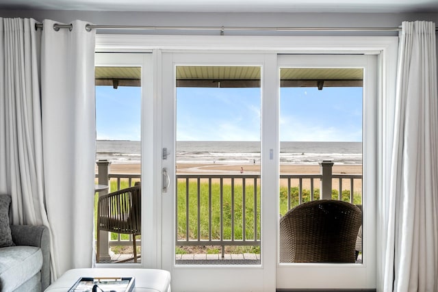 doorway featuring a water view, a view of the beach, and plenty of natural light