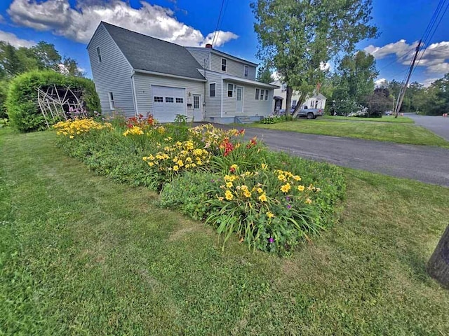 view of front facade with a garage and a front lawn