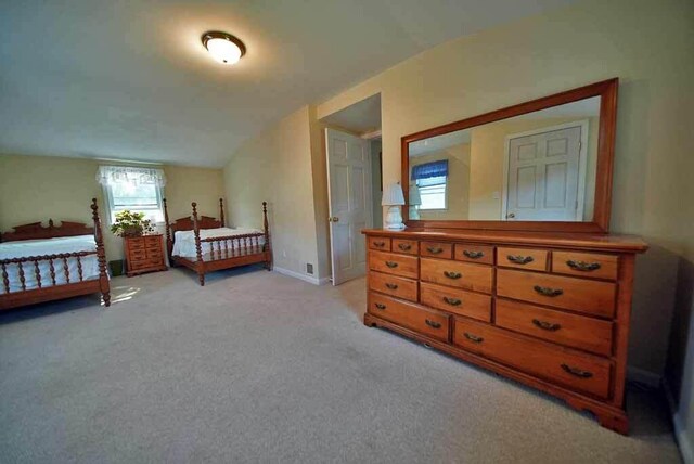 carpeted bedroom featuring lofted ceiling