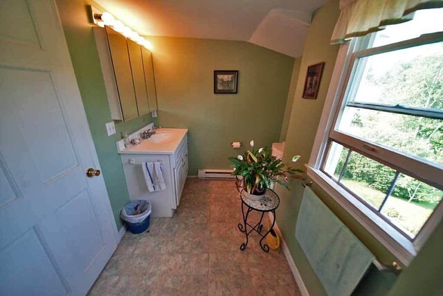 bathroom featuring vaulted ceiling, vanity, baseboard heating, and tile patterned floors