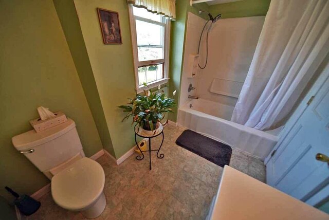 bathroom featuring toilet, tile patterned floors, and shower / bath combination with curtain