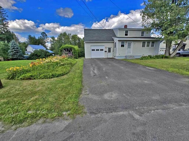 front facade featuring a garage and a front yard