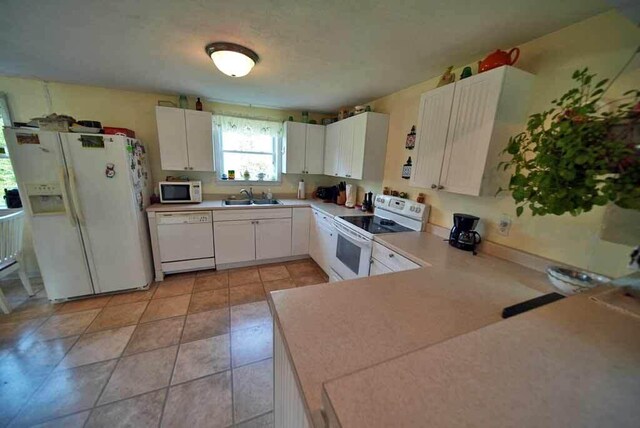 kitchen featuring white cabinetry, light tile patterned floors, white appliances, sink, and kitchen peninsula