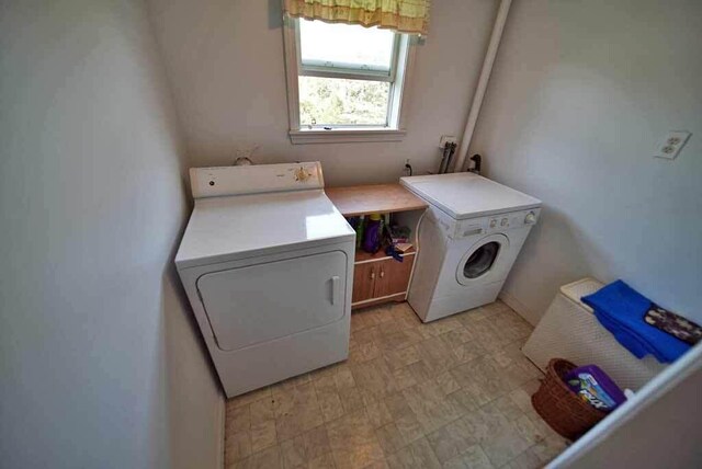 washroom with washing machine and dryer and light tile patterned floors