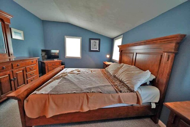 bedroom featuring lofted ceiling and carpet flooring