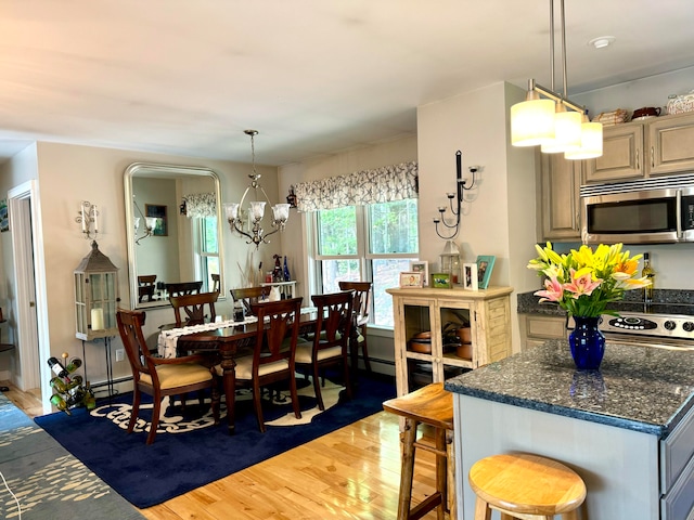 dining room featuring a baseboard heating unit, wood-type flooring, and a notable chandelier