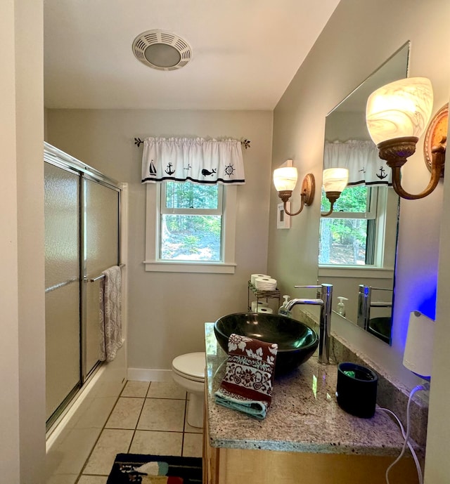 bathroom featuring walk in shower, tile patterned floors, sink, and toilet