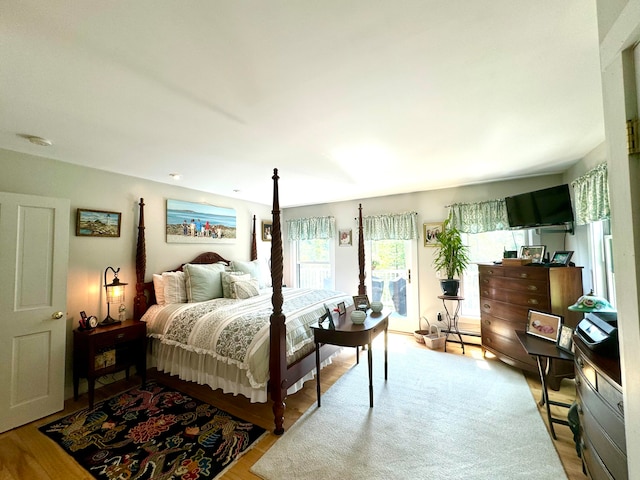 bedroom with baseboard heating and light wood-type flooring