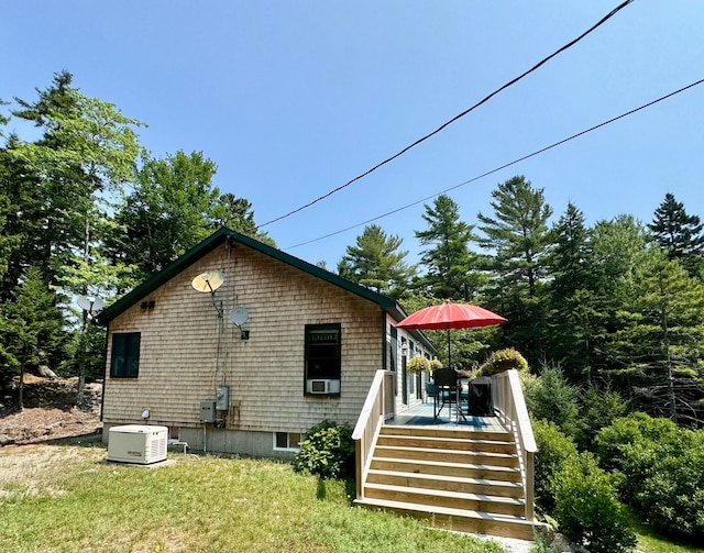 back of house featuring cooling unit, a deck, and a lawn