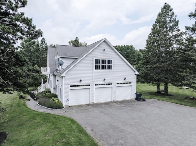 view of home's exterior featuring a garage, a yard, and a balcony