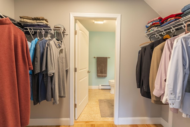 walk in closet featuring light hardwood / wood-style floors and a baseboard heating unit