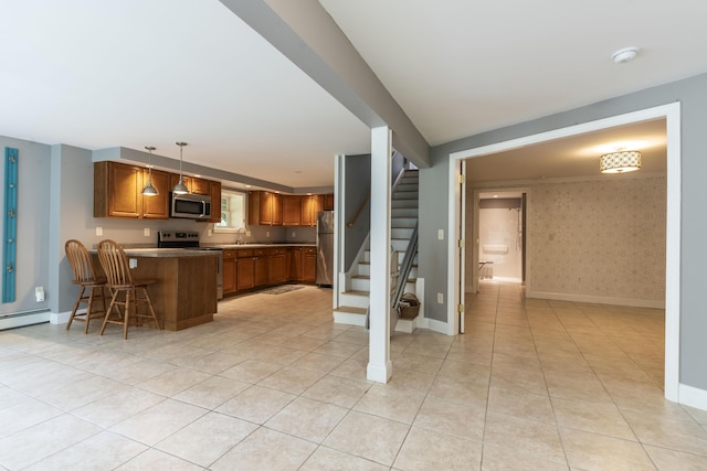 kitchen featuring kitchen peninsula, stainless steel appliances, light tile patterned floors, a kitchen breakfast bar, and pendant lighting