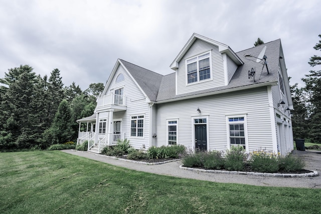 view of front property with a front lawn and a balcony