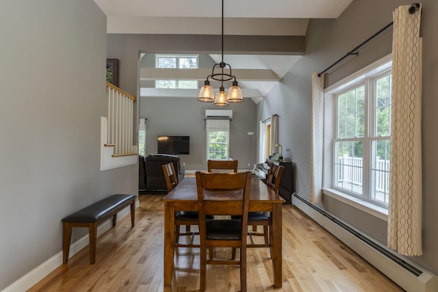 dining area featuring an AC wall unit, a chandelier, light hardwood / wood-style floors, and baseboard heating