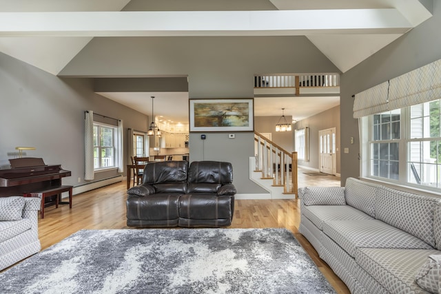 living room with a baseboard heating unit, high vaulted ceiling, a chandelier, and light hardwood / wood-style floors