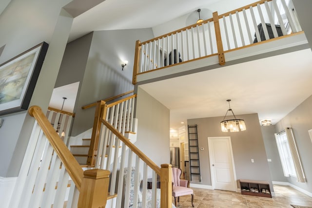 stairway with a notable chandelier and a high ceiling