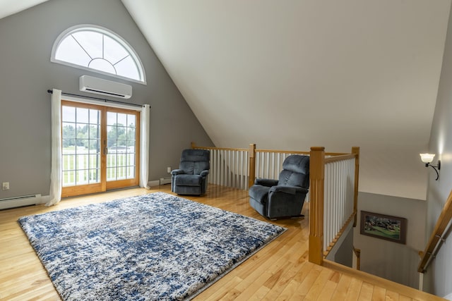 sitting room with a wall mounted air conditioner, a wealth of natural light, hardwood / wood-style floors, and a baseboard radiator