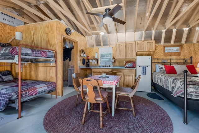 bedroom with white fridge, ceiling fan, vaulted ceiling, and concrete floors