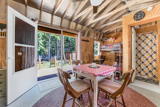 dining room featuring lofted ceiling and concrete flooring