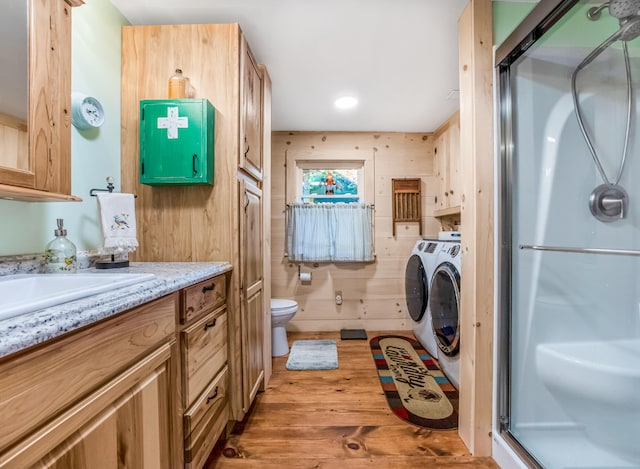 bathroom with walk in shower, wood walls, toilet, vanity, and hardwood / wood-style floors