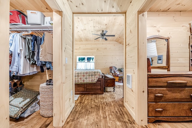 hallway with light hardwood / wood-style floors, wooden walls, and wood ceiling