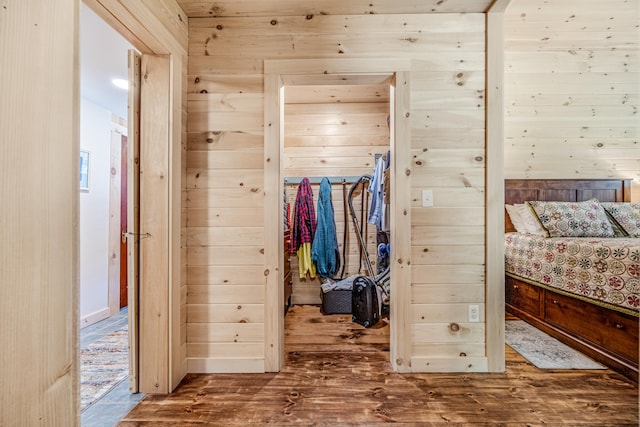 unfurnished bedroom with wood walls and wood-type flooring